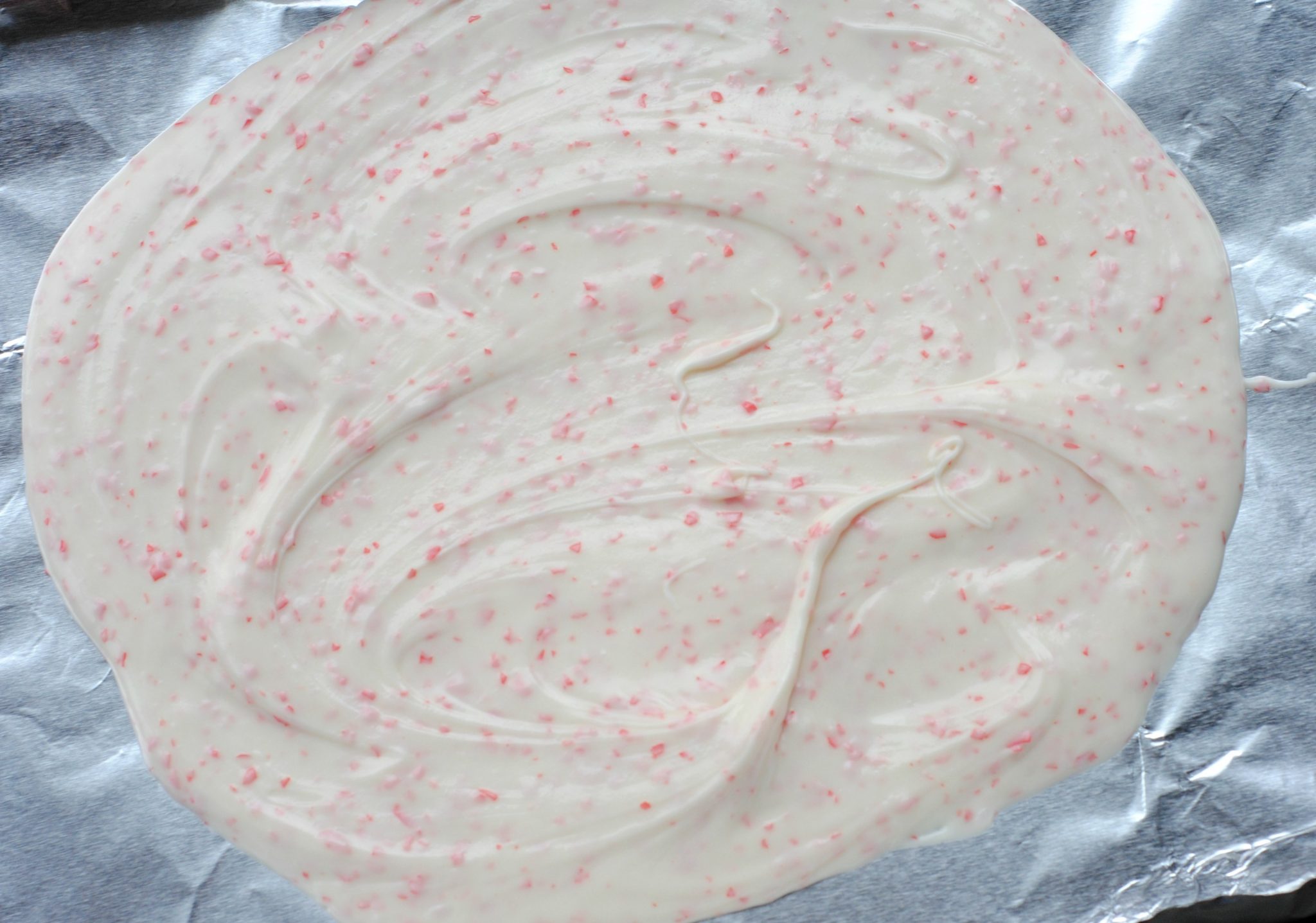 white chocolate and peppermint candies melted on tin foil