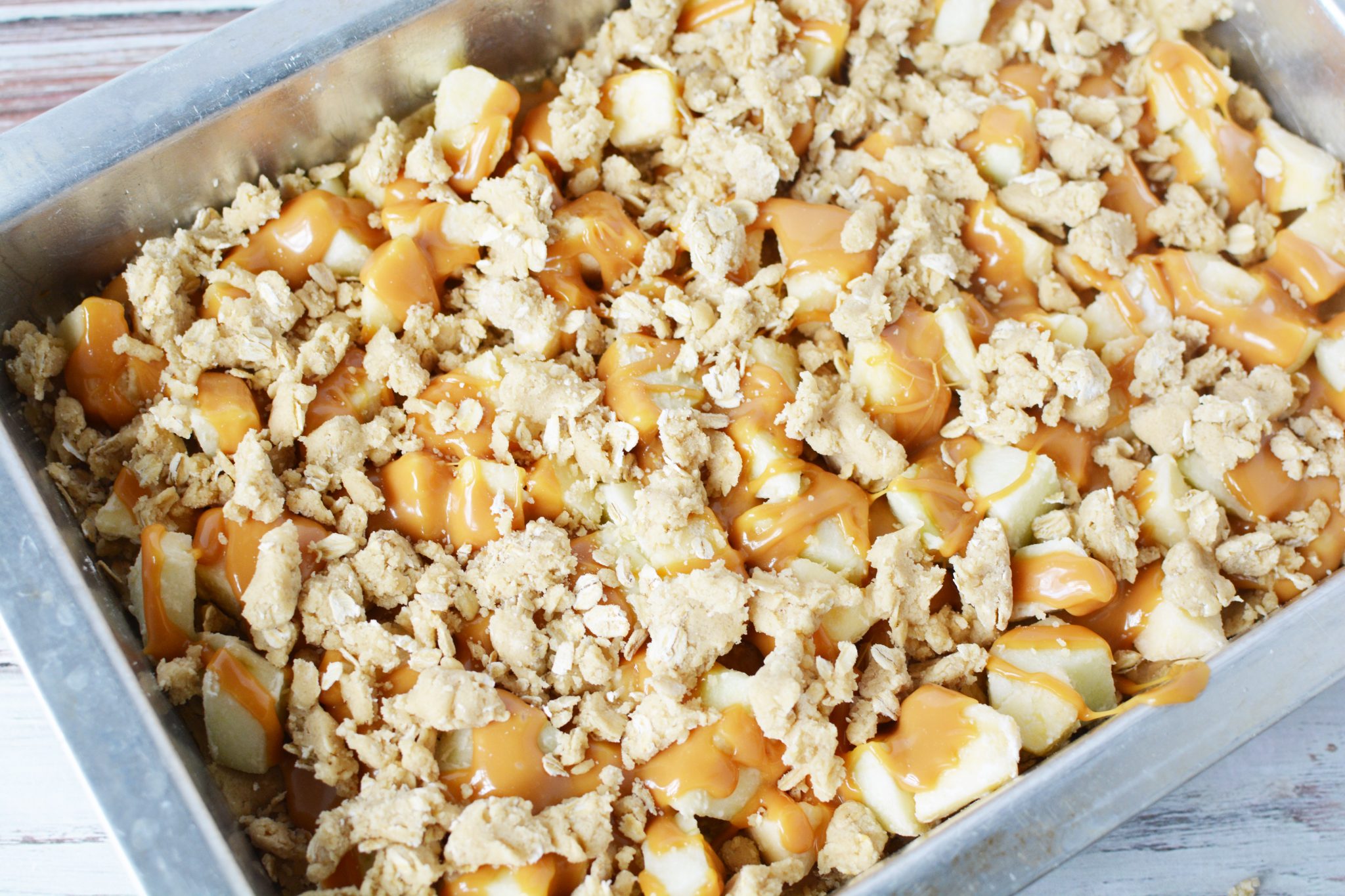 oatmeal crust with apples and caramel in a baking pan with oatmeal crisp on top