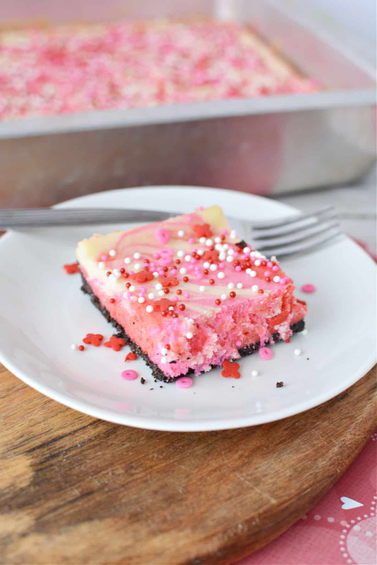 Cheesecake Bars with an oreo crust and covered in red white and pink sprinkles