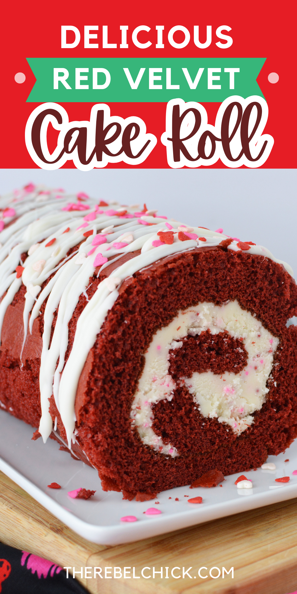 Red Velvet Cake Roll covered in white frosting with red and pink sprinkles