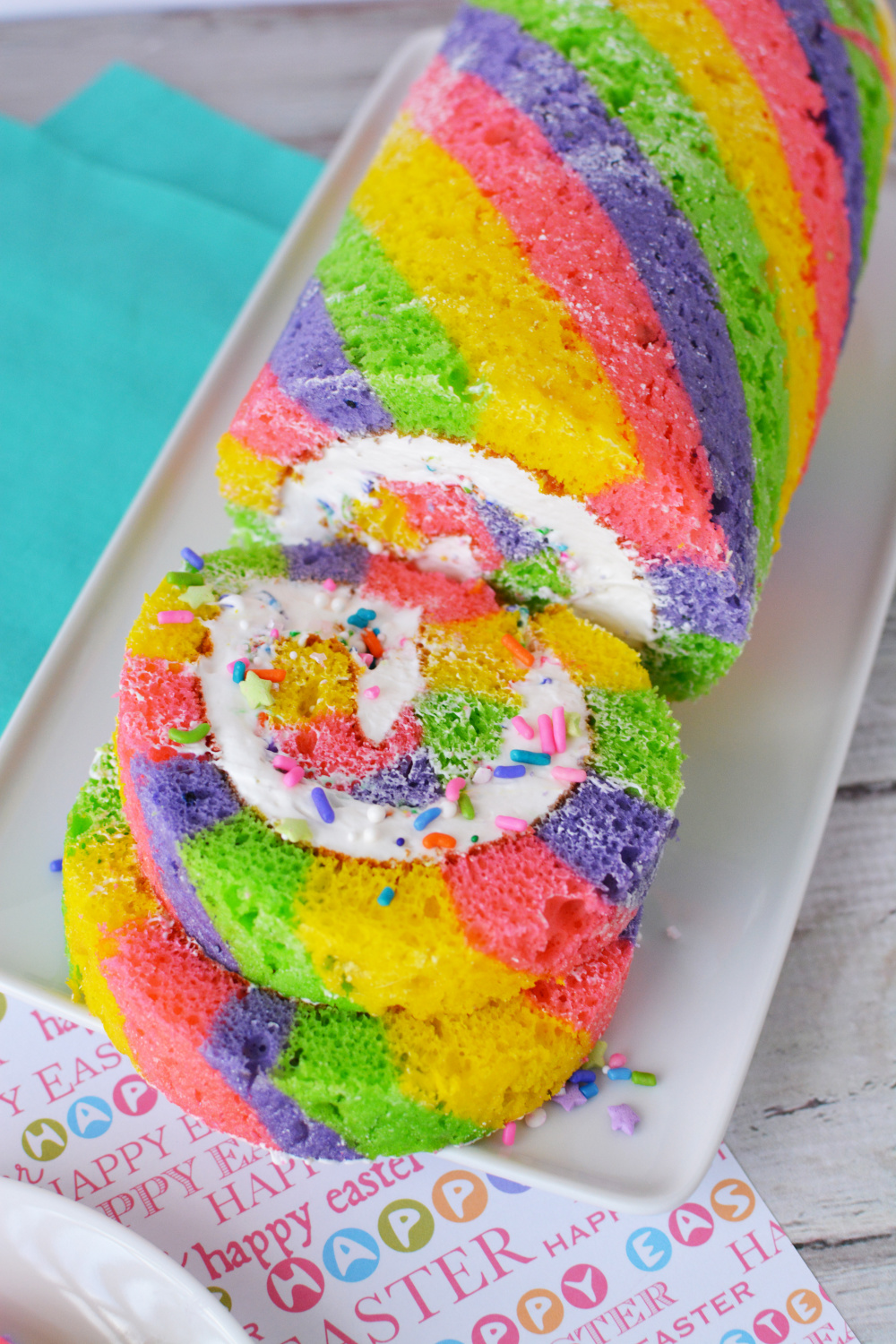pink, yellow, purple and green easter cake roll filled with white frosting