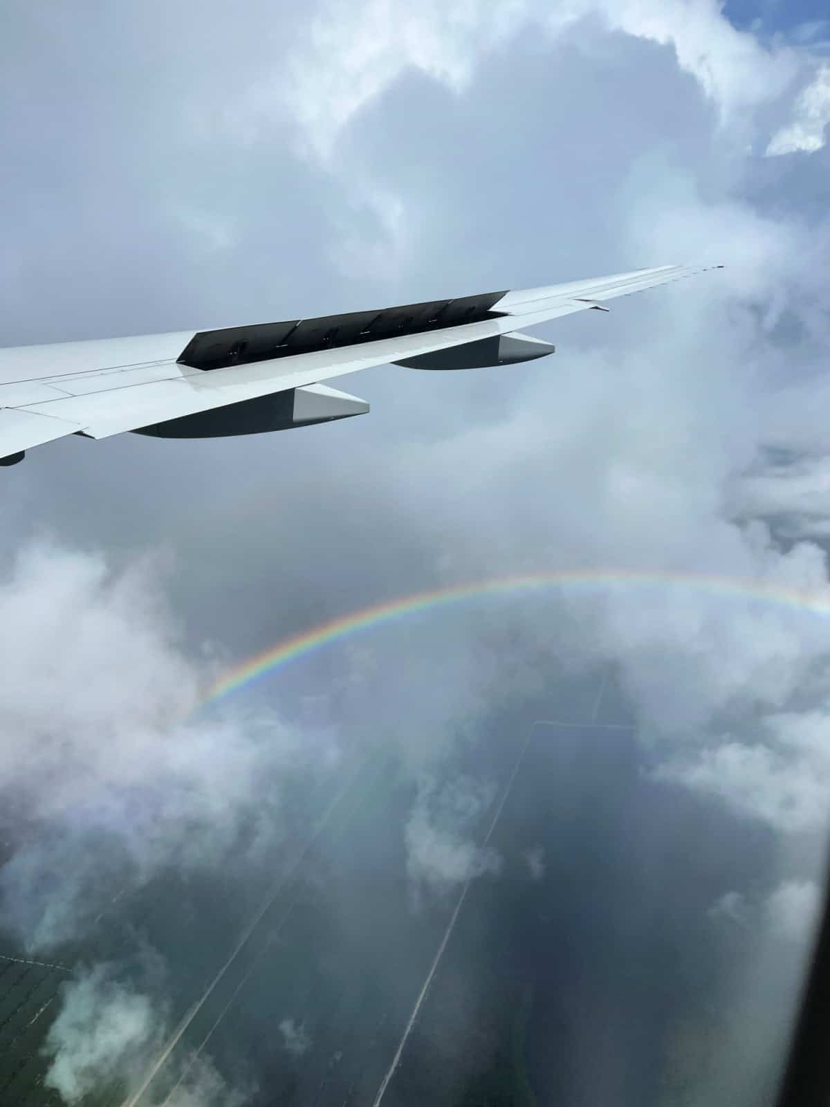 airplane wing and a rainbow in the sky