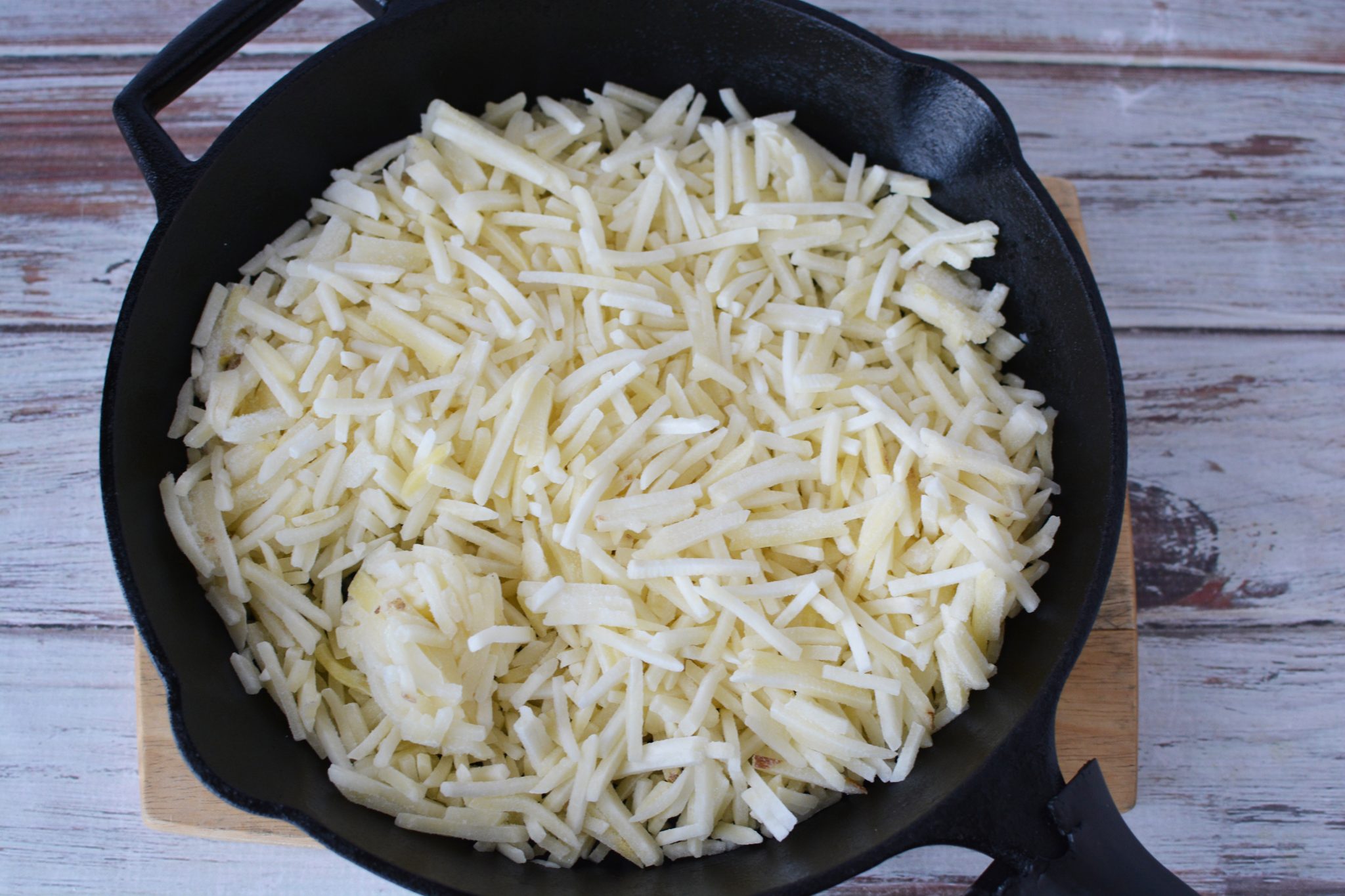 Frozen hashbrowns in a cast iron skillet 