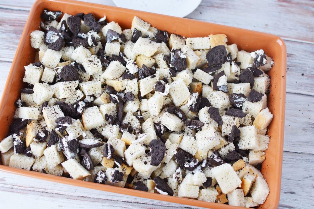 Cubes of bread and Oreo cookie crumbles in a casserole dish 