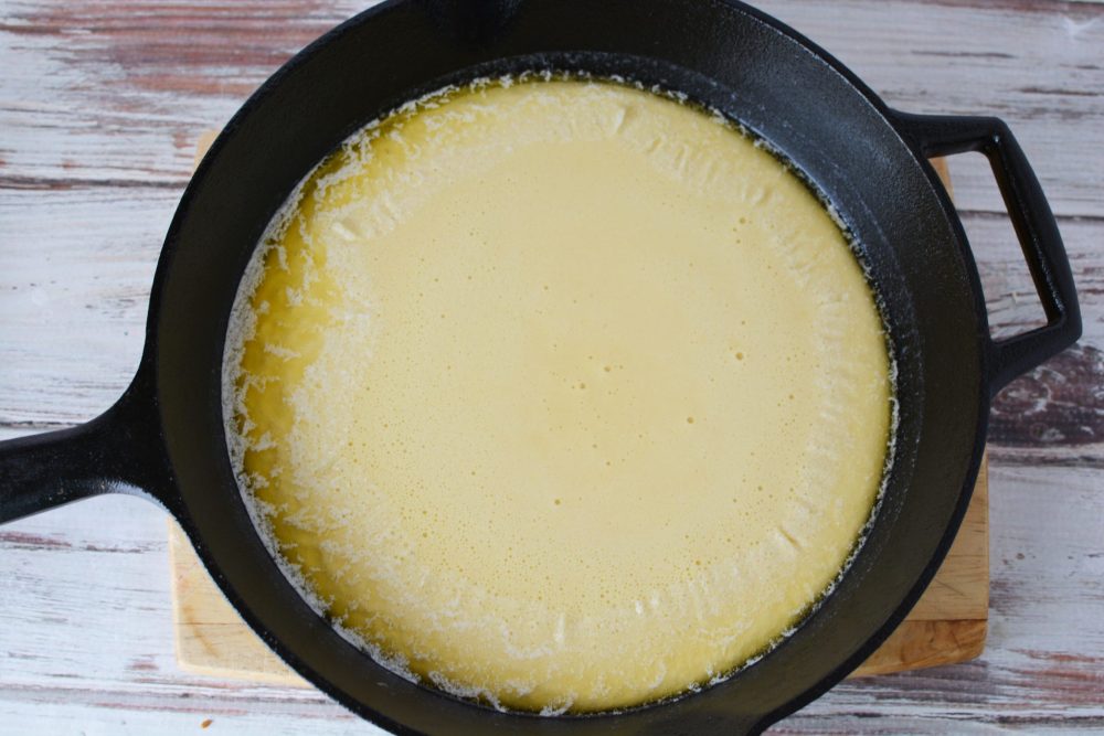 pancake batter in a cast iron skillet