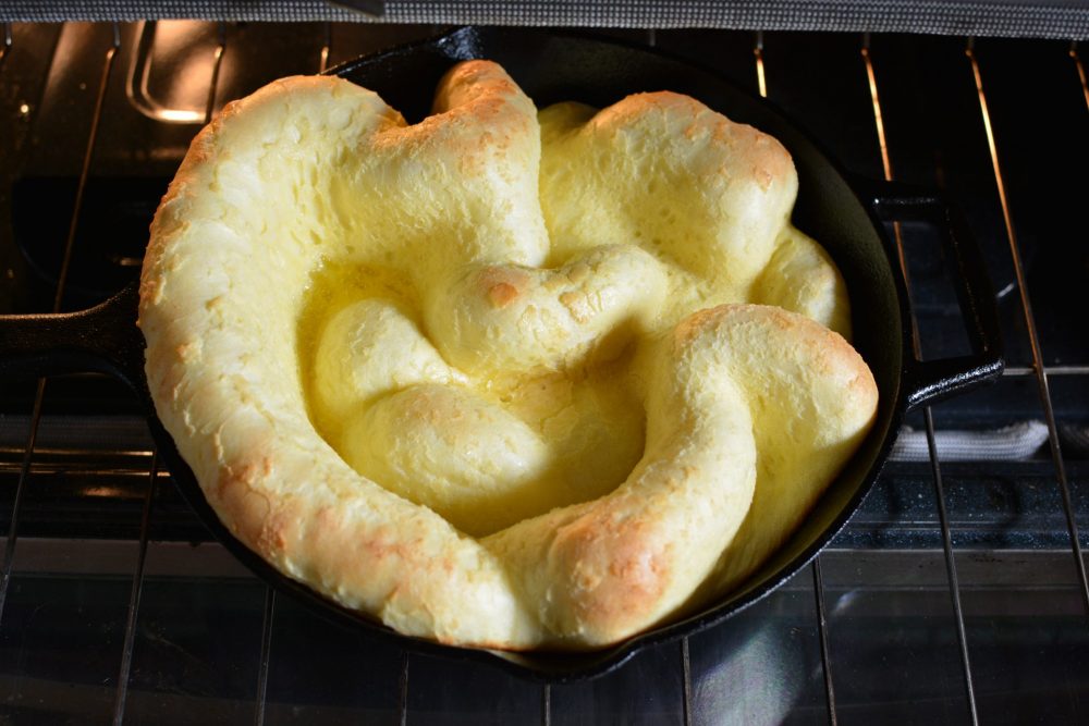 puffy pancake in a cast iron skillet in the oven