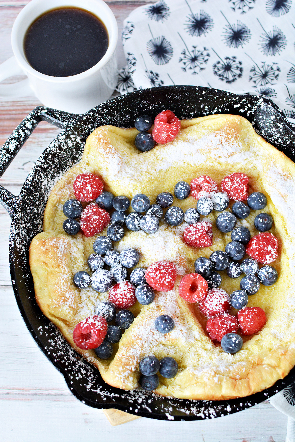 Puffed Pancake filled with raspberries, blueberries and sprinkles of powdered sugar