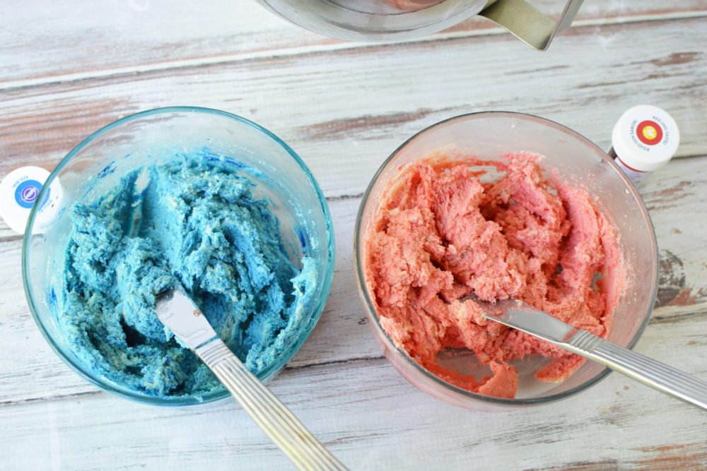 Red and blue cookie dough in different bowls