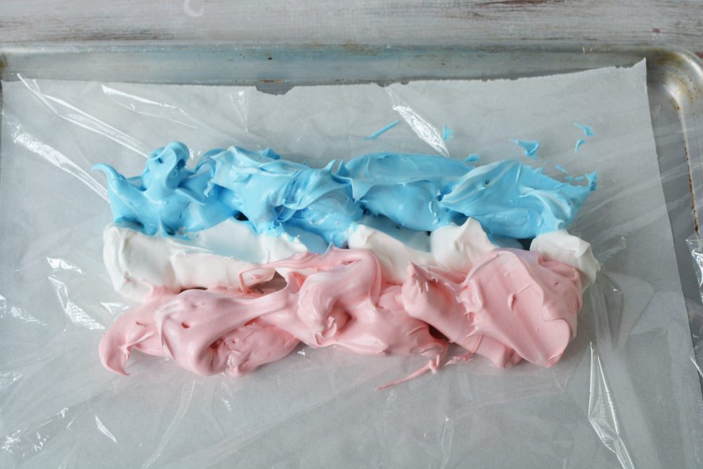Red, white and blue meringue on a sheet of plastic wrap