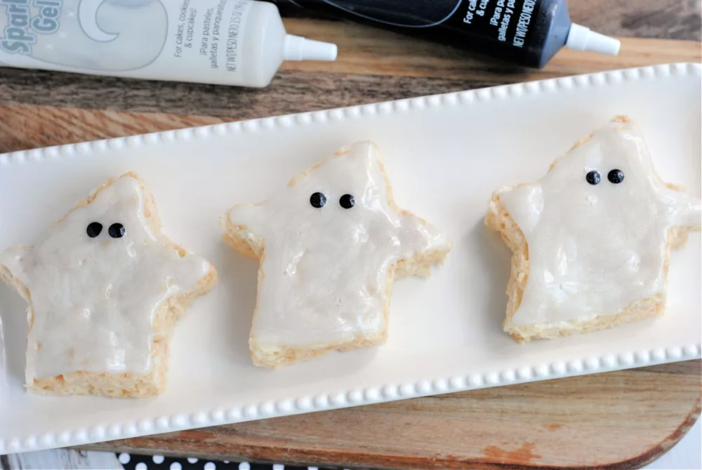 Ghost shaped crisped rice cereal treats with white icing and black eyes