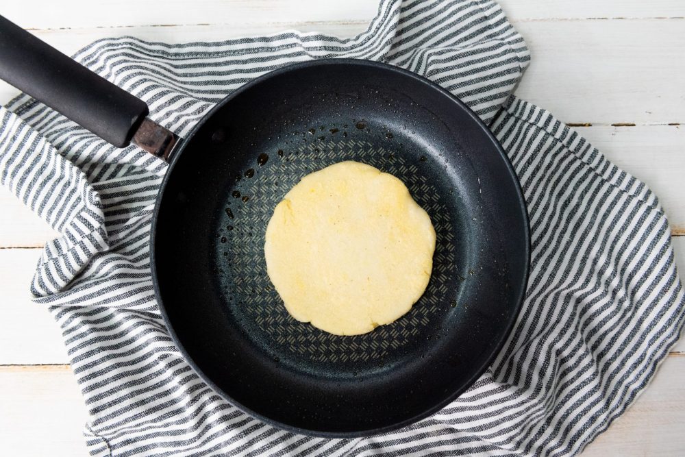 Frying the arepa in a skillet 