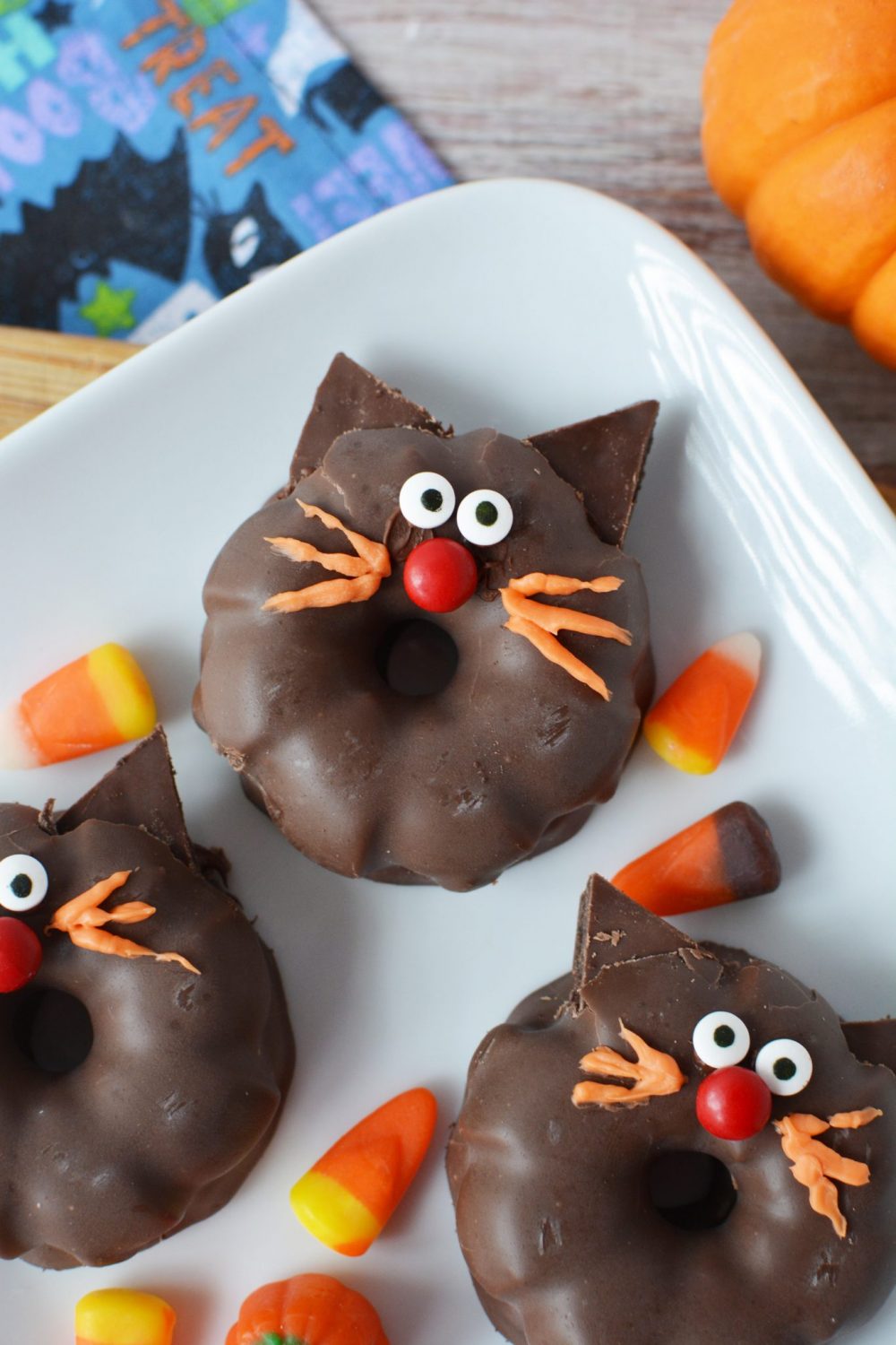 Black Cat Cookies with orange frosting whiskers, googly eyes and red nose
