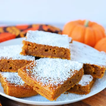 Pumpkin Bars with Cake Mix on a plate covered in powdered sugar