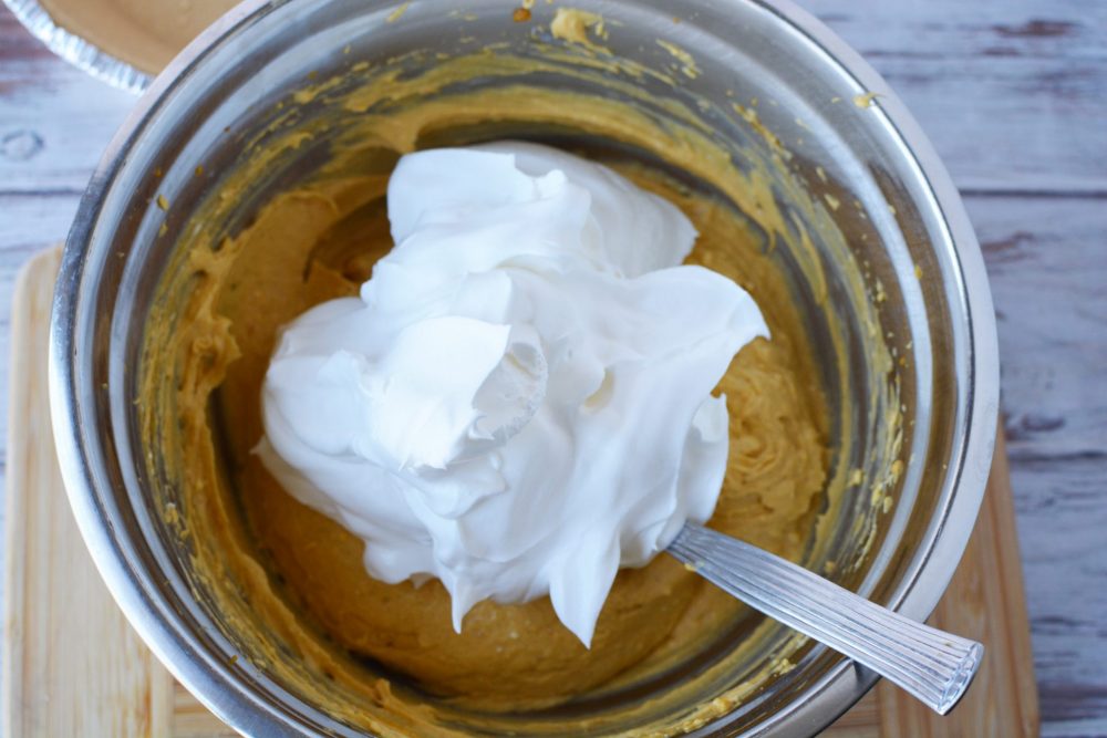 Adding whipped cream to the pumpkin cheesecake filling 