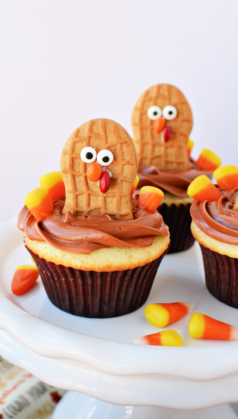 Vanilla cupcakes with chocolate frosting and Nutter Butter cookies decorated like Turkeys with candy corns
