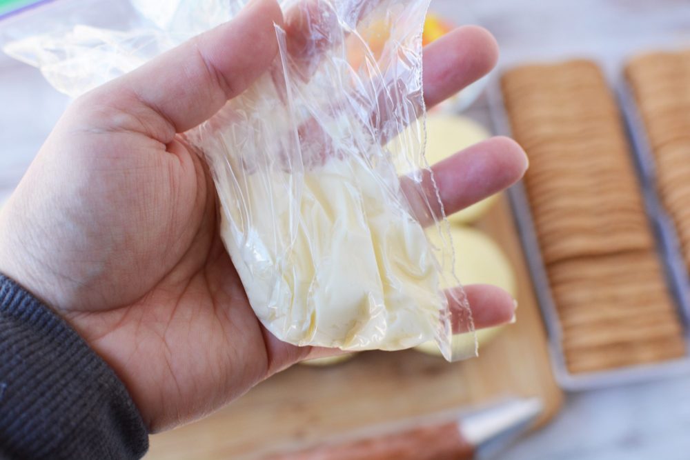 Adding frosting to a plastic bag. 