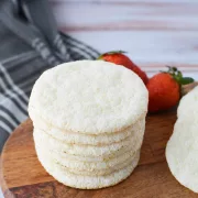 Angel Food Cake Mix Cookies on a wooden cutting board with fresh strawberries in the background