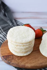 Angel Food Cake Mix Cookies on a wooden cutting board with fresh strawberries in the background