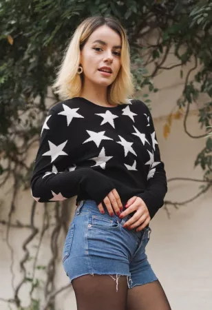 blonde girl wearing a black sweater with white hearts for Valentine's day
