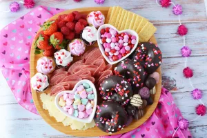 Galentines Charcuterie Board filled with candies, meats, cheeses and sweets in a colorful arrangement