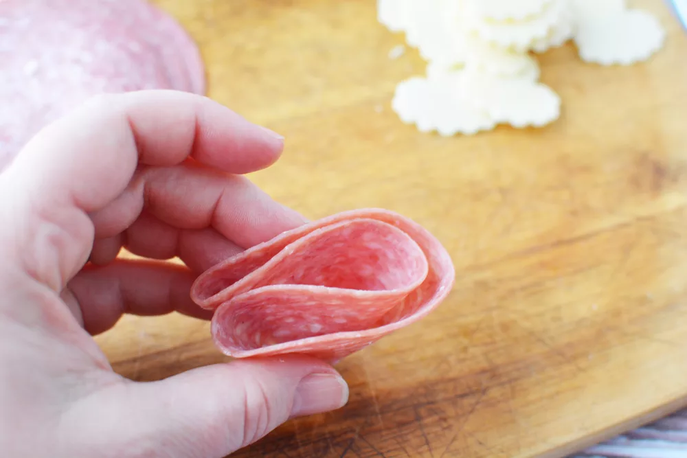 Fold salami rounds in half and half again to make a double folded piece.