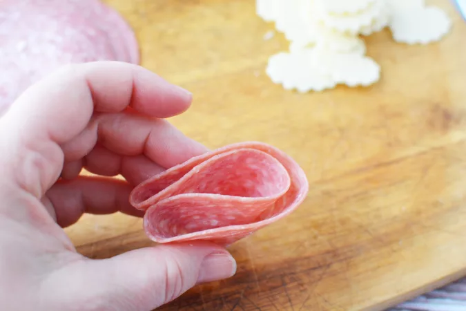 Fold salami rounds in half and half again to make a double folded piece.