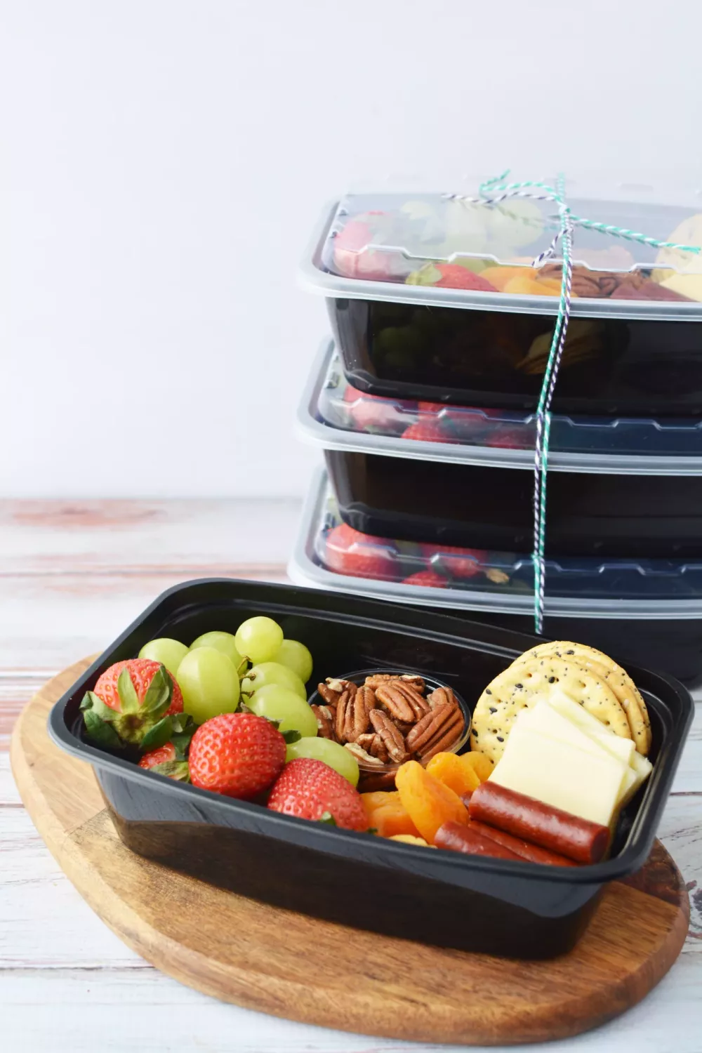 Mini Charcuterie Box filled with cheese, fresh fruit, crackers, pretzels, dried apricots, nuts and meats
