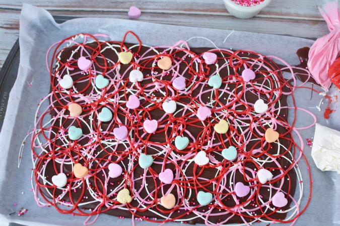 Repeat with additional colors and on the last color add conversation hearts to the melted candy.