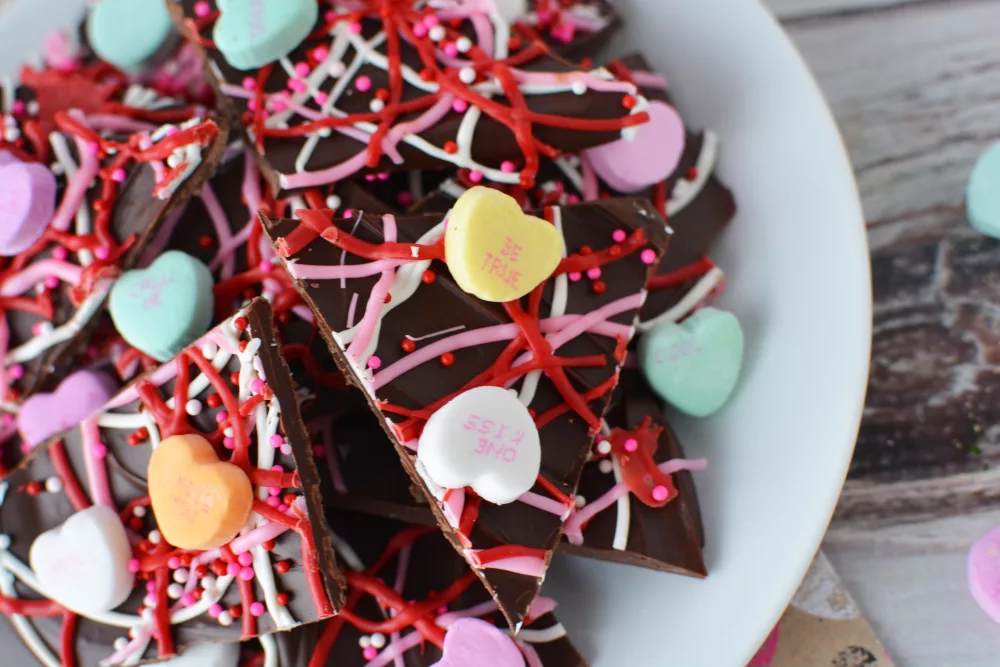 chocolate bark covered in valentines day sprinkles and conversation hearts