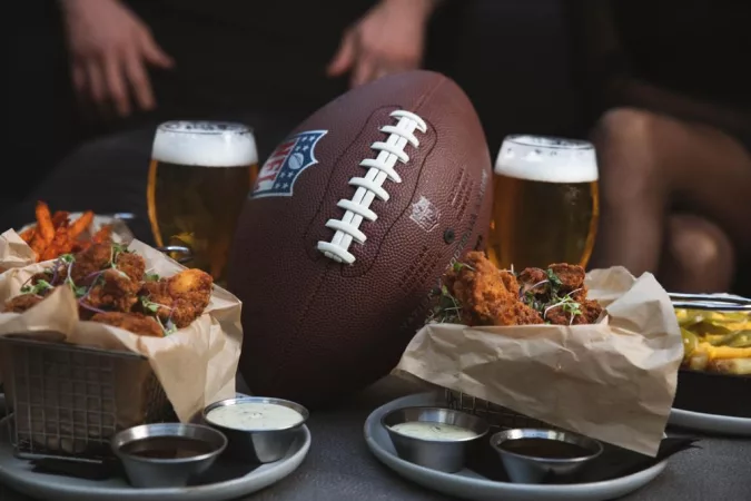 Football on a table surrounded by food and drinks