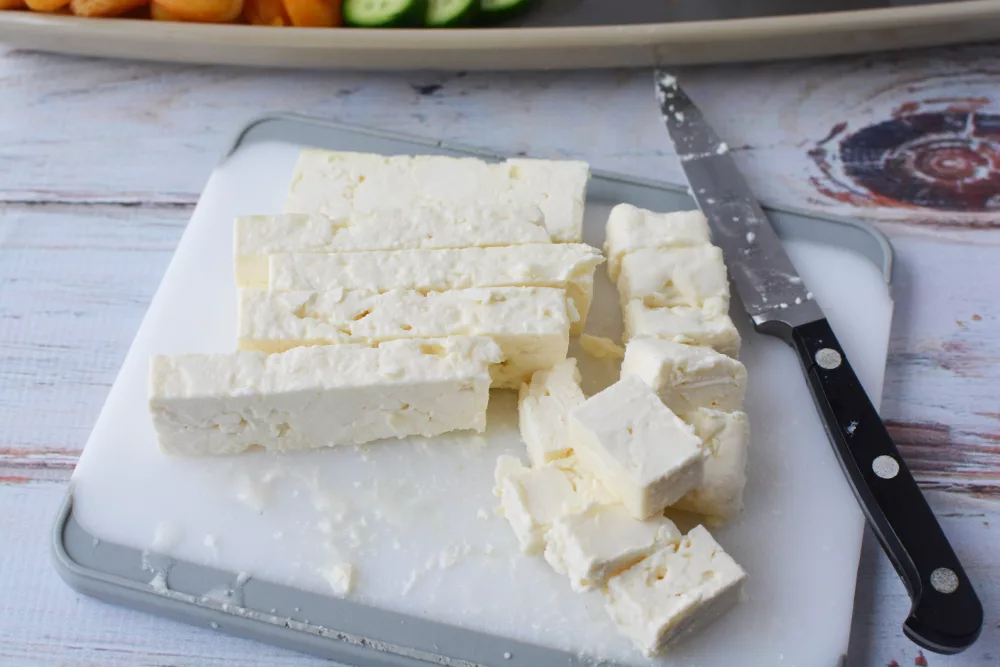 feta cheese cut on a plastic cutting board