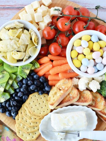 Spring Charcuterie Board filled with fresh fruits and fresh veggies, cheese, crackers and candies