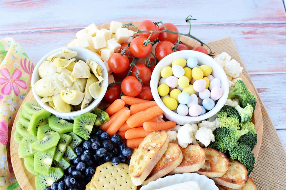 Spring Charcuterie Board filled with fresh fruits and fresh veggies, cheese, crackers and candies