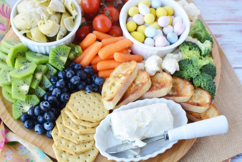 charcuterie platter filled with fresh vegetables, fresh fruits, crackers and cheese and Easter candies