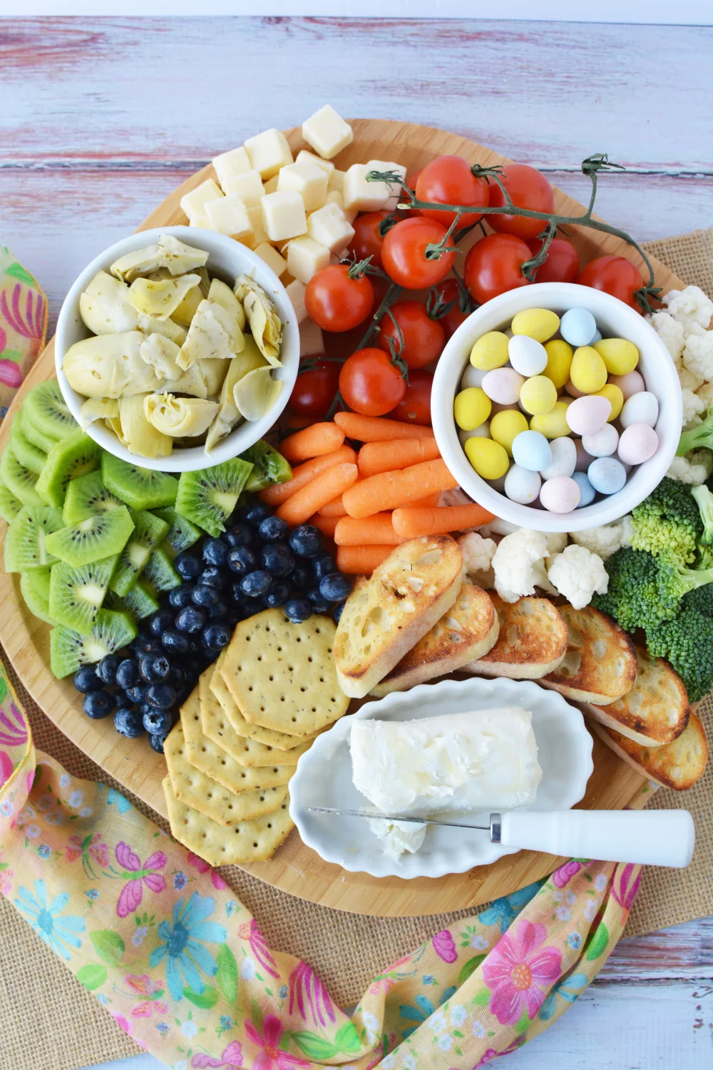 charcuterie platter filled with fresh vegetables, fresh fruits, crackers and cheese and Easter candies