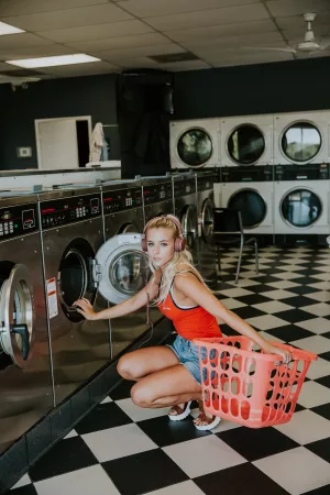 woman standing in front of a commercial washing machine with an exasperated look on her face