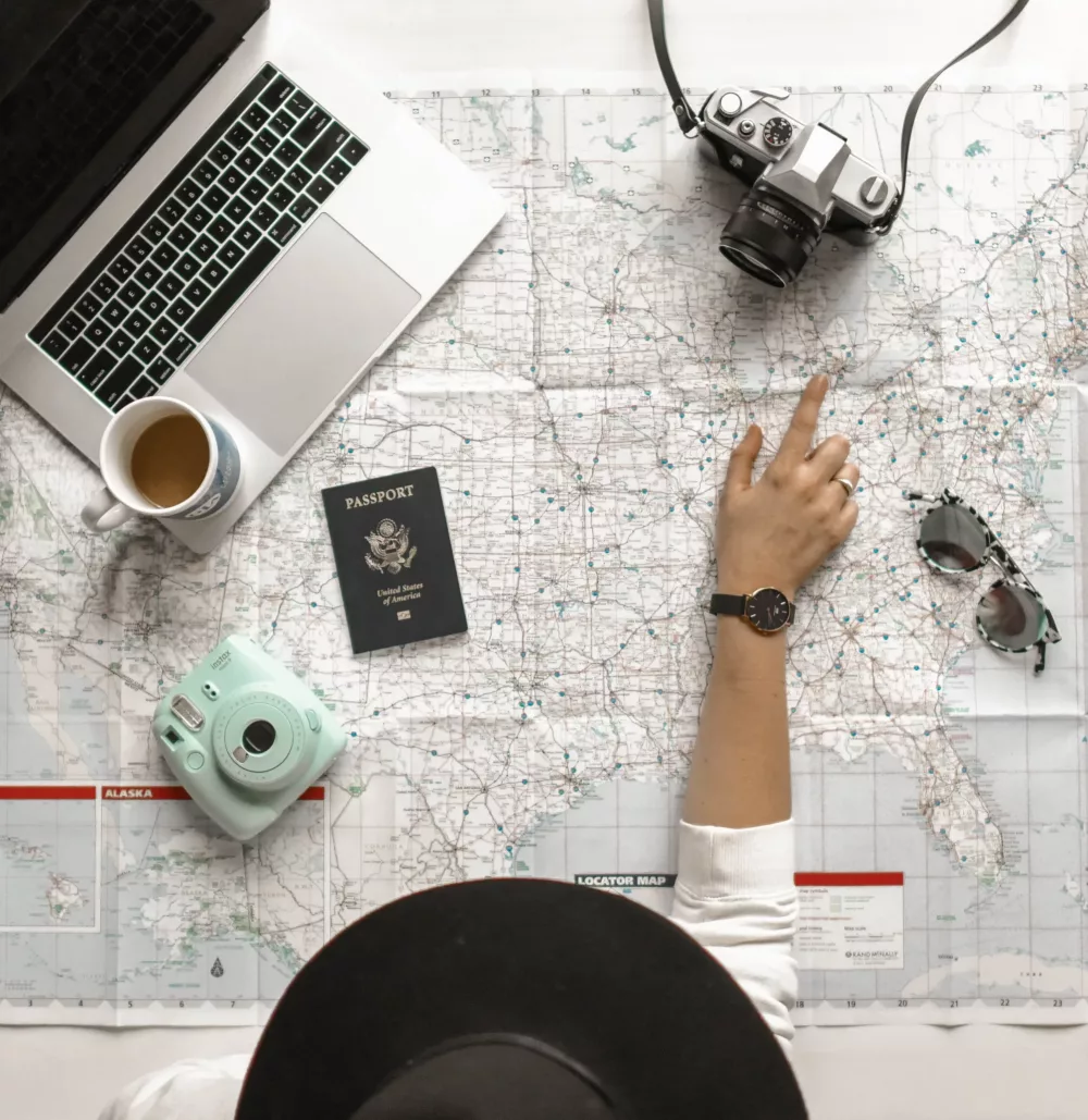 woman in a hat planning travel with a map