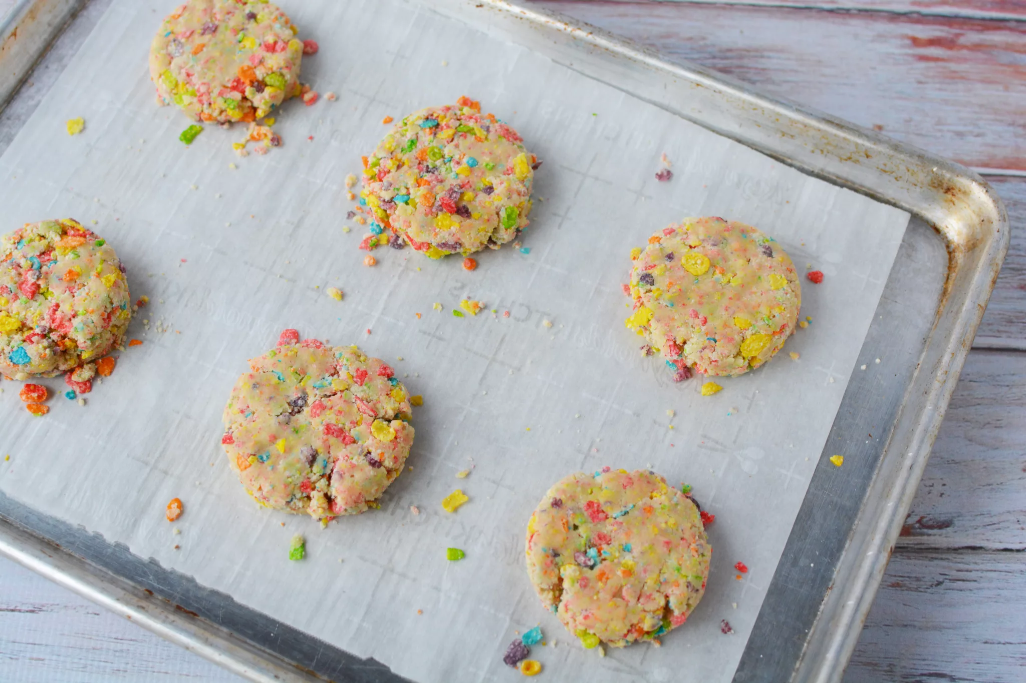 Fruity Pebbles Cookie dough balls on a parchment paper lined baking sheet