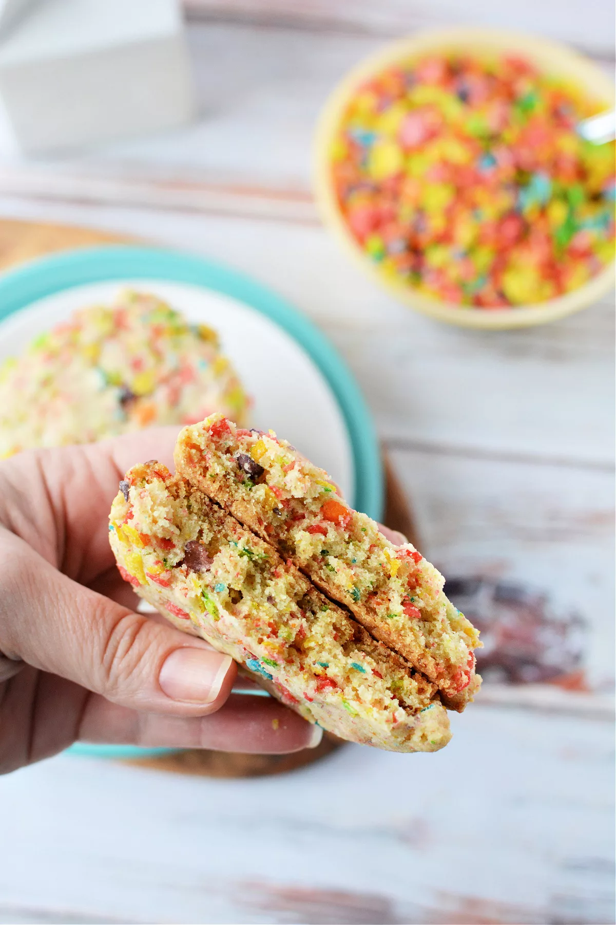 hand holding a cookie filled with cereal 