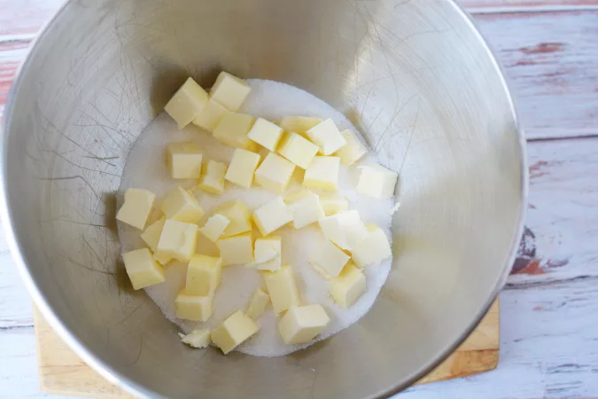 sugar and butter being beaten together in a large mixing bowl