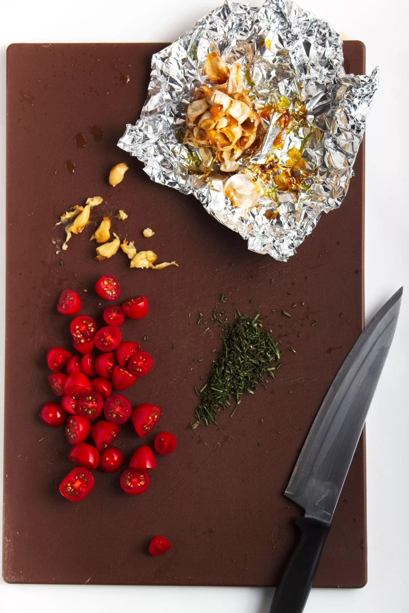 halved cherry tomatoes, rosemary and garlic cloves