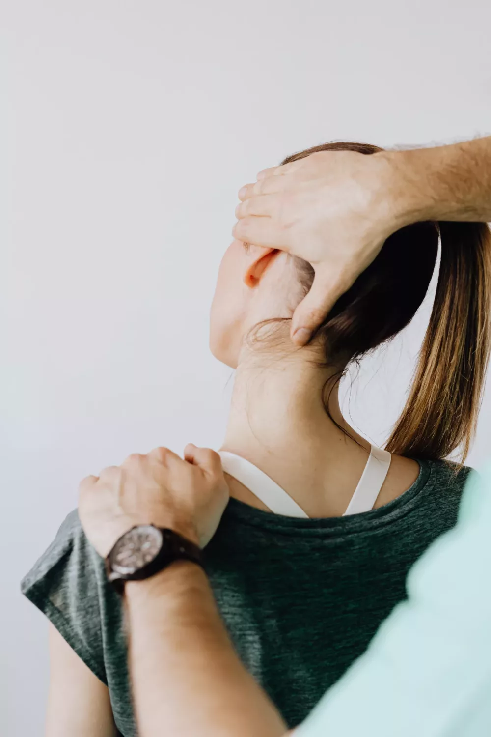 woman having her neck examined while in pain from an injury
