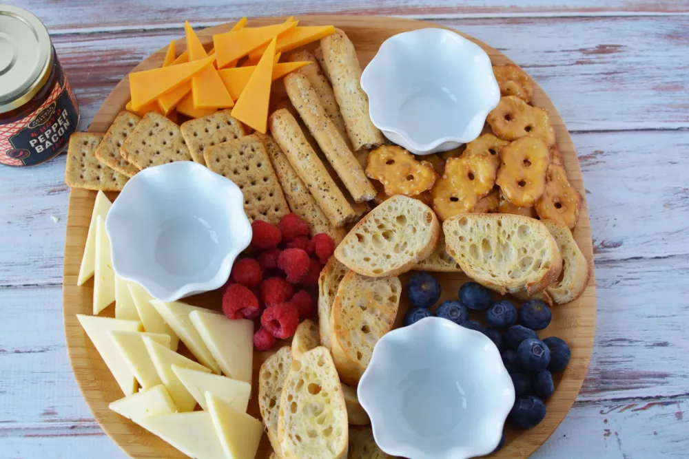 cheese board filled with crackers and cheeses and spreads for Mothers Day Charcuterie Board 