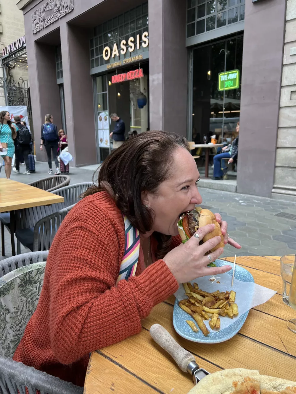 jennifer wearing a Merokeety cardigan while eating a burger in Barcelona