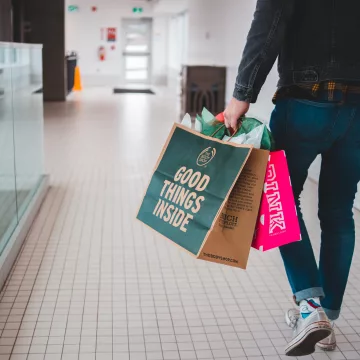 person carrying shopping bags in a mall