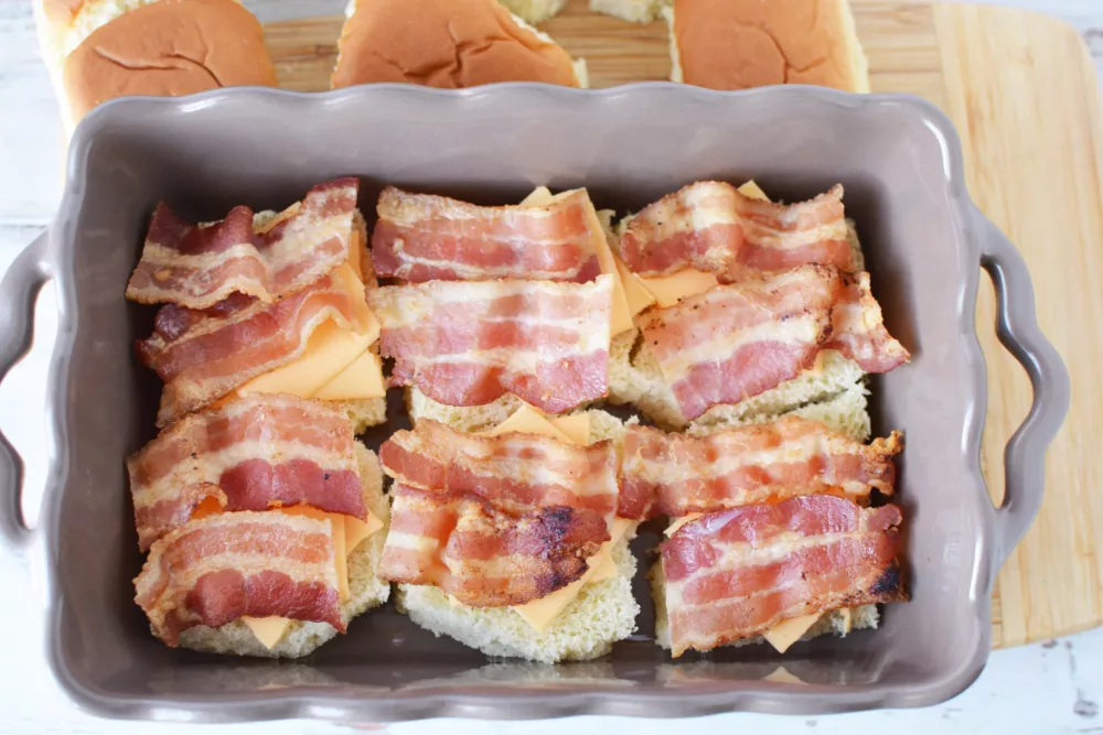 bacon slices on top of cheese and buns