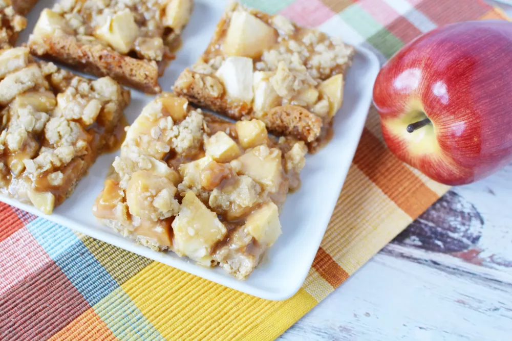 oatmeal bars covered in chunks of apples and drizzled with caramel