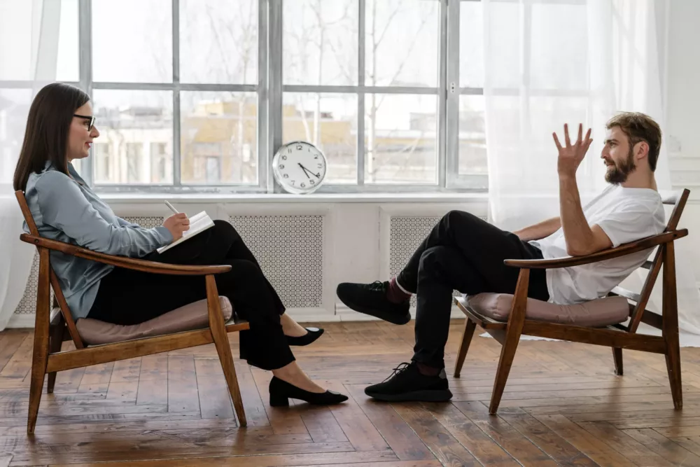person sitting in a chair with a therapist