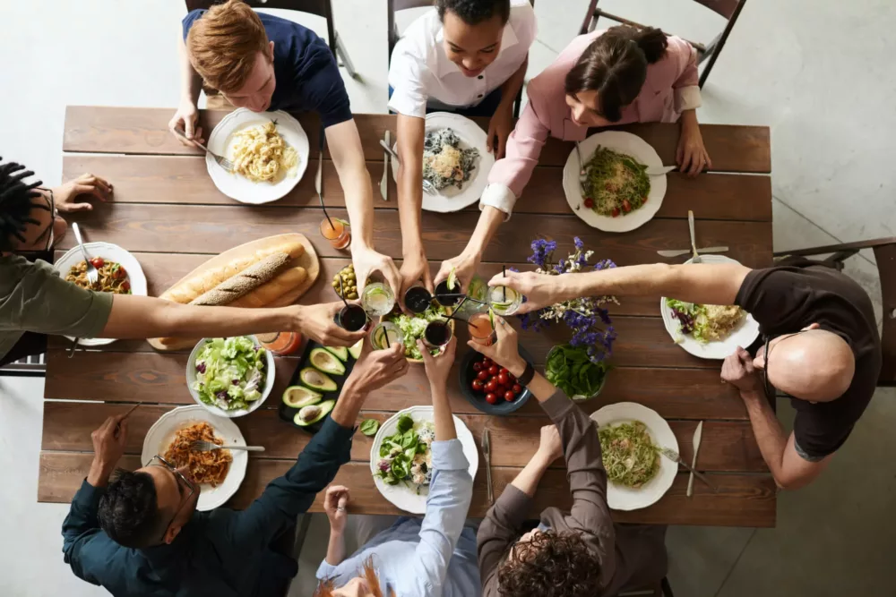 people cheering over a set dinner table