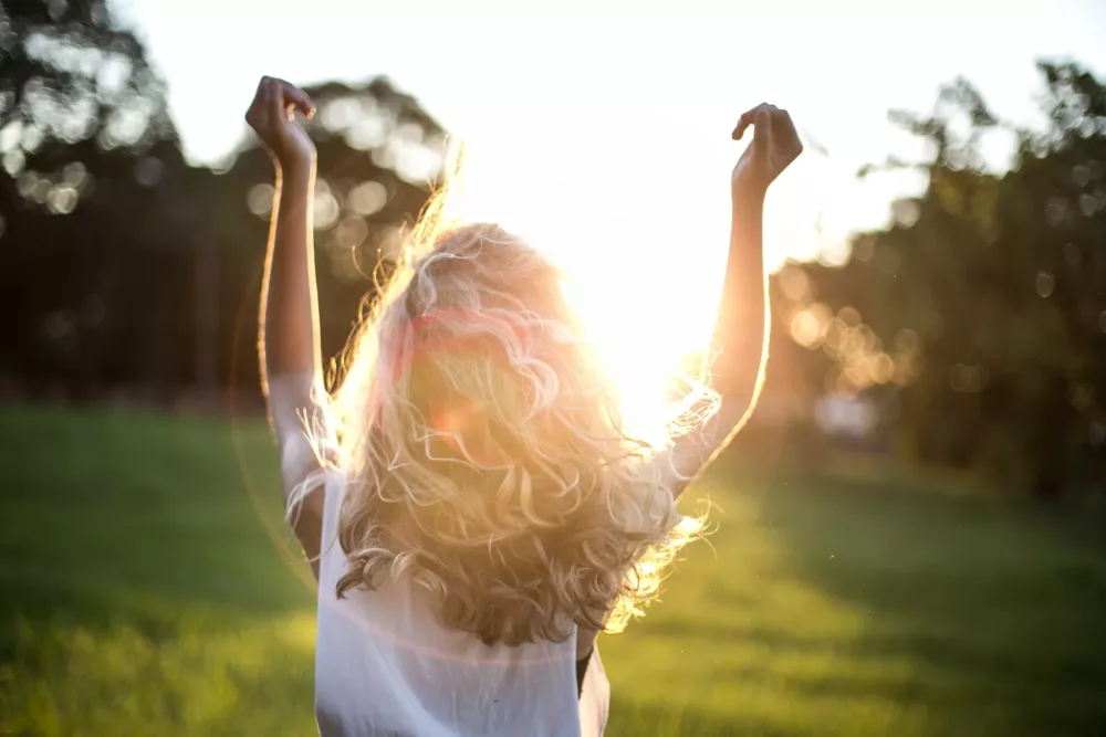 happy woman raising her hands to the sky